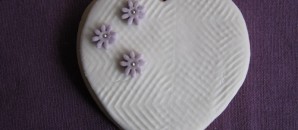 Galleta de corazón blanco con margaritas lilas